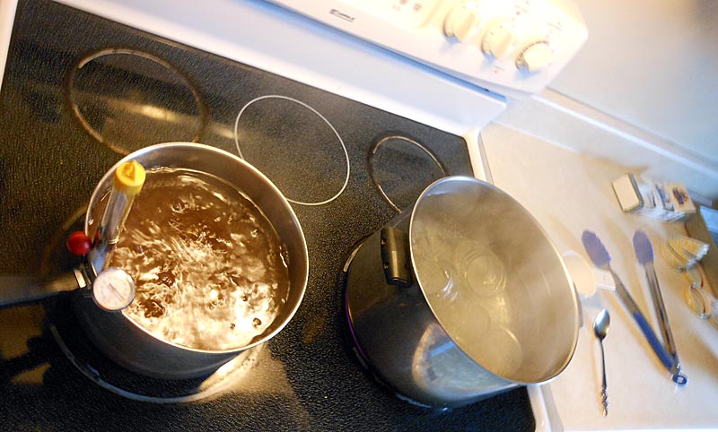 Finishing the maple syrup boiling process on the kitchen stove